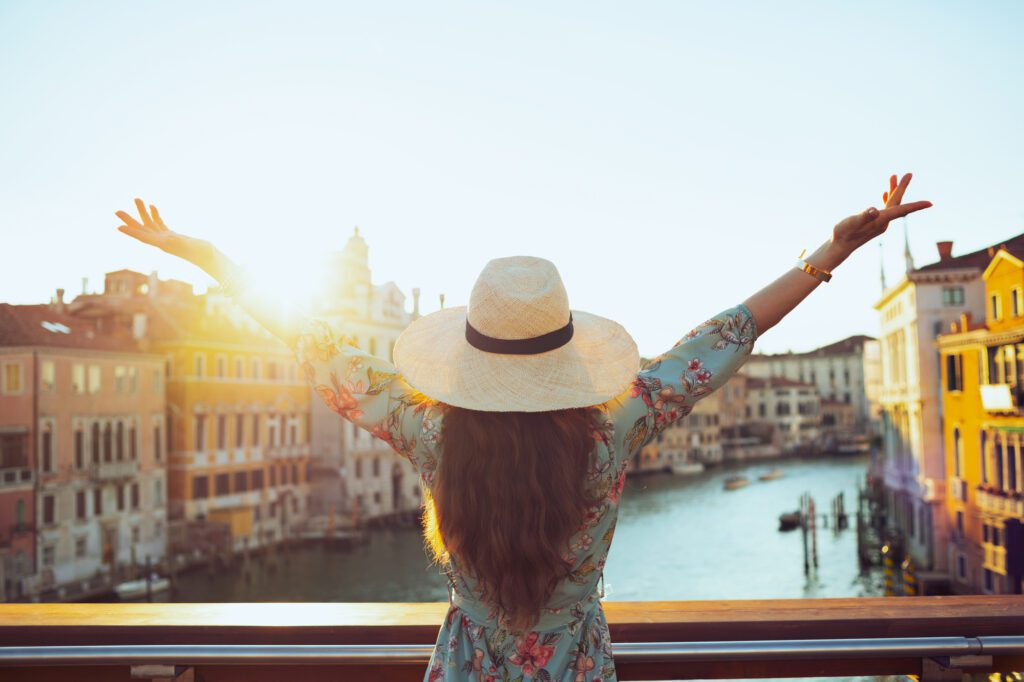 Seen from behind young solo traveller woman in floral dress