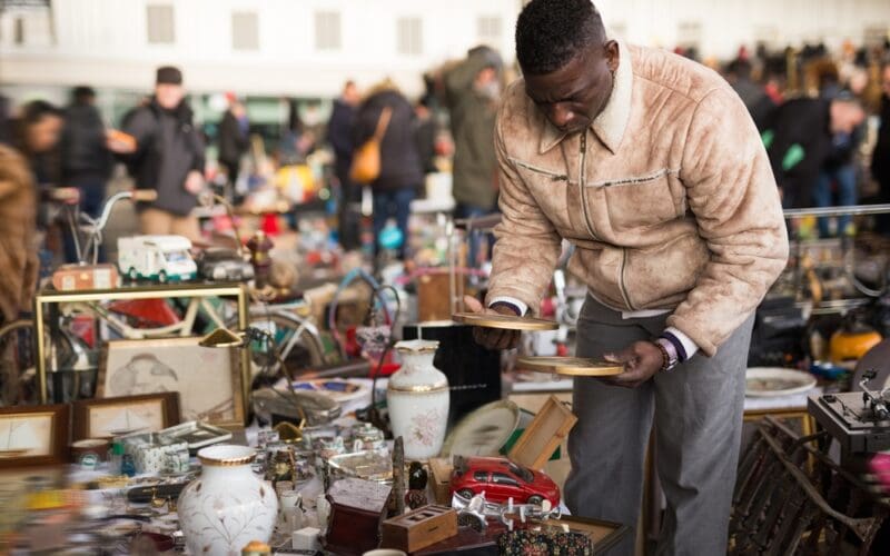 Afro-american,Guy,Considers,Things,Sacond,Hands,On,Flea,Market