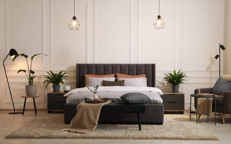 Stylish,Bedroom,Interior,With,Large,Comfortable,Bed,,Armchair,And,Ottoman