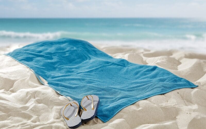 Towel,Spread,On,Hot,Beach,Sand,With,Empty,Space,For