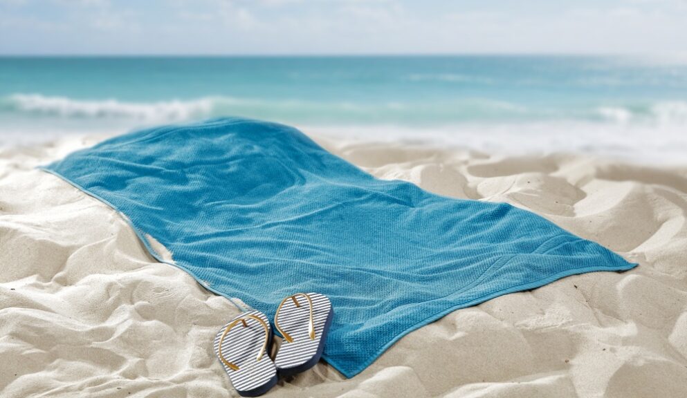 Towel,Spread,On,Hot,Beach,Sand,With,Empty,Space,For