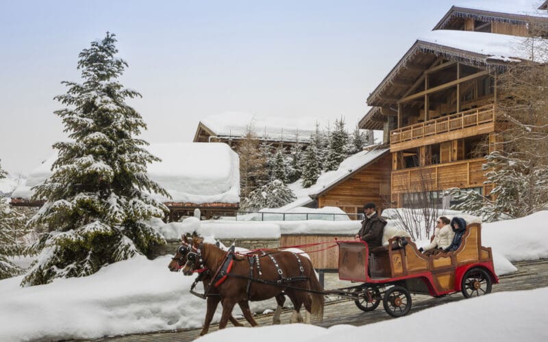 Four Seasons Megève resort in snow with skiers on the slopes of Mont d'Arbois below Mont Blanc