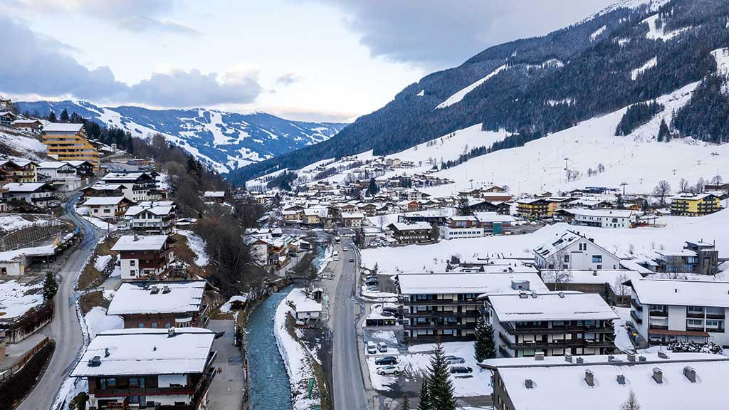 Skiers on a sunny piste above the village at the start of the Val d'Isère ski season in the French Alps