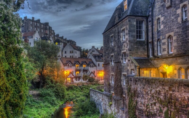 Guide holding a lantern in an underground Edinburgh close during Halloween in Scotland